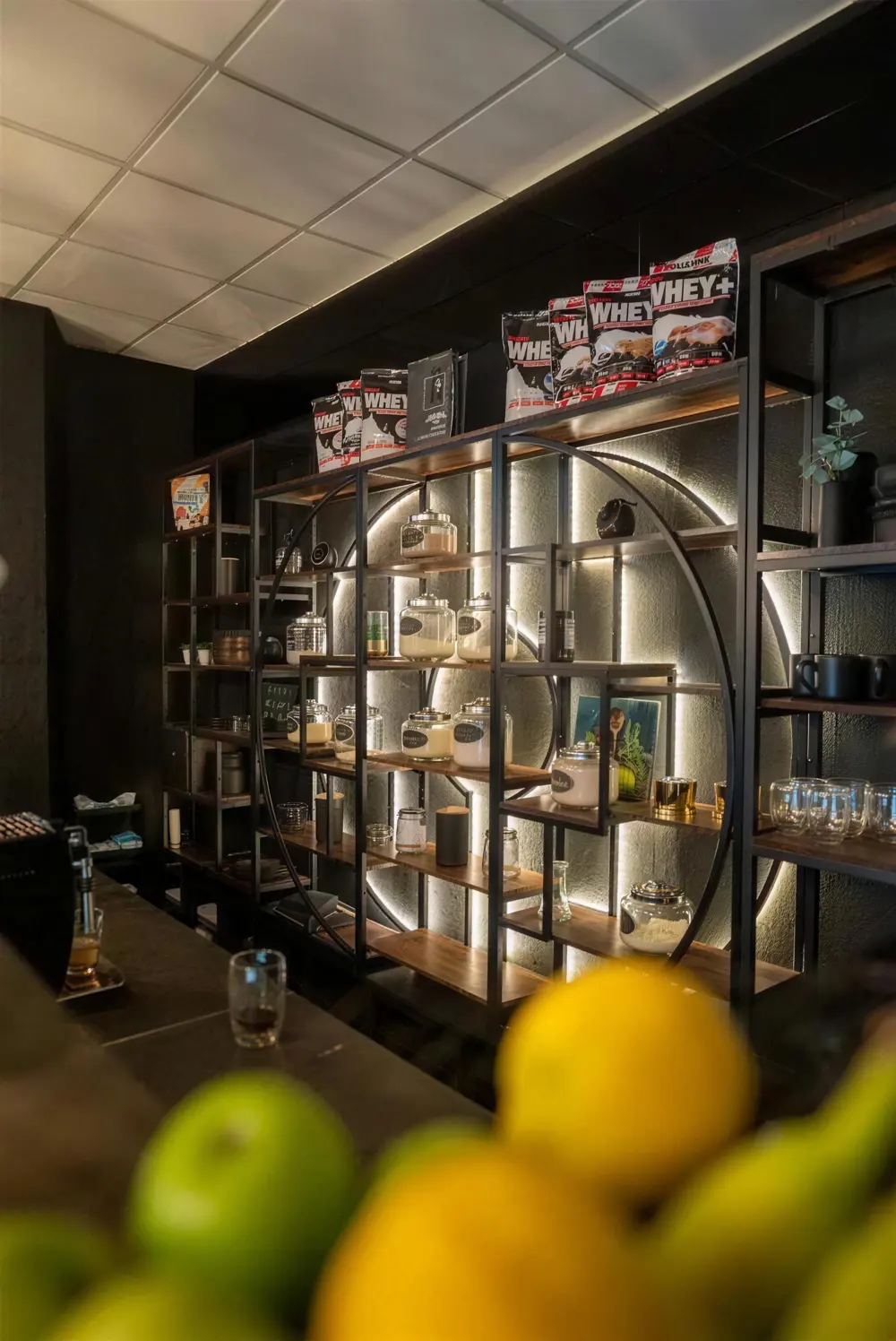 Regal mit Gläsern, Proteinprodukten und Getränken an der Bar